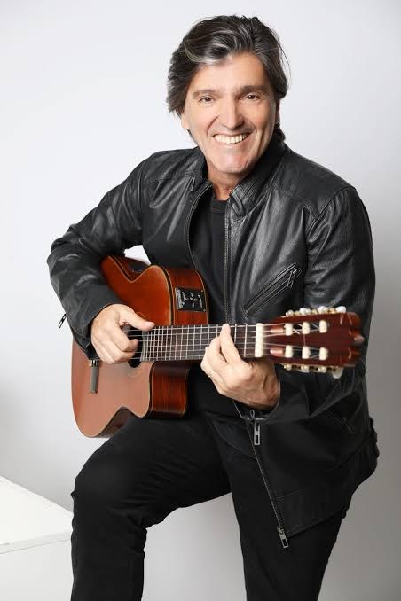 Nico Rezende sentado com violão